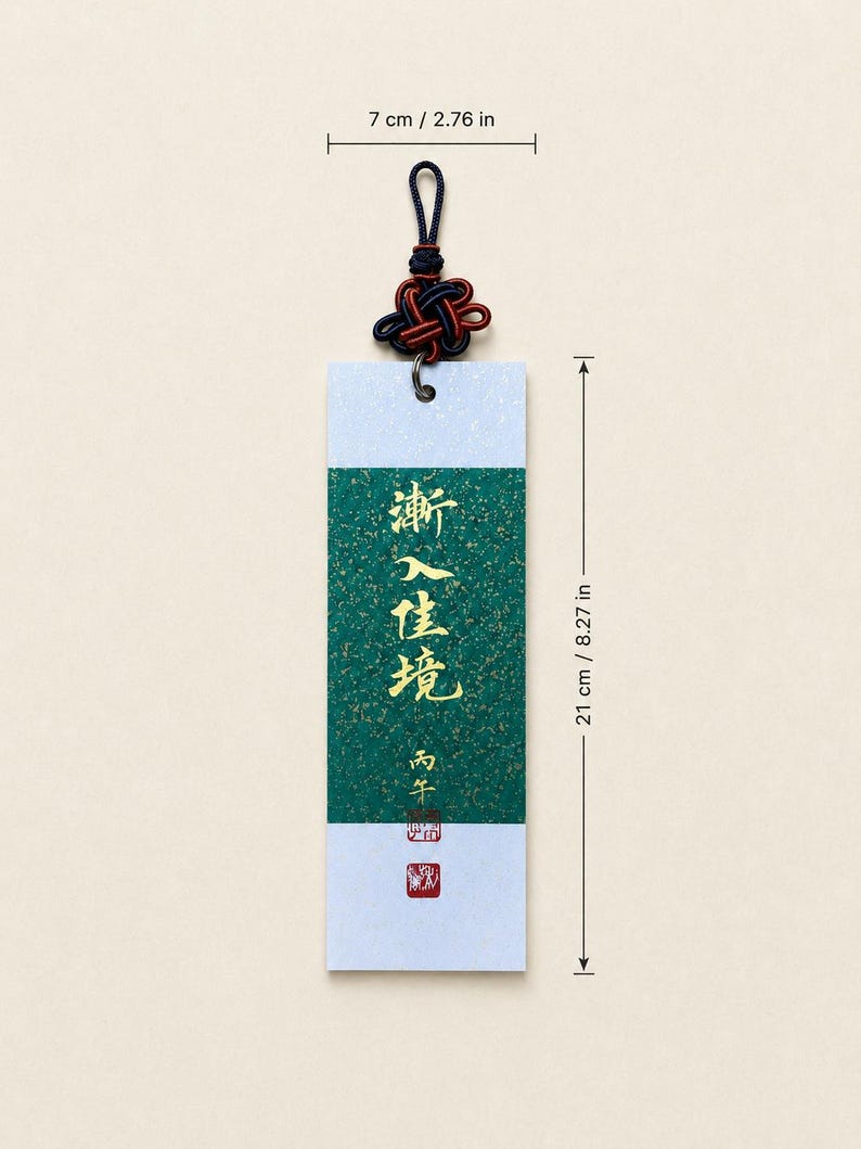 May include: A rectangular bookmark featuring a central green panel with gold flecks and gold Chinese calligraphy, bordered by white sections. It includes a dark blue and red decorative knot at the top. Dimensions are 7 cm wide by 21 cm long.