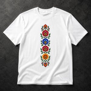 Op de afbeelding: Een wit t-shirt met korte mouwen en een verticale, gecentreerde grafische print van een bloemenpatroon. Het ontwerp bestaat uit vier gestileerde, kleurrijke bloemen in rood, blauw, roze en geel, omringd door groene bladeren.