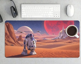 May include: A rectangular desk mat featuring a desert landscape with a large red planet and a white and blue droid. A white coffee cup, keyboard, mouse, and headphones are also visible.