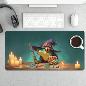 May include: A whimsical desk mat featuring a green frog wearing a purple wizard hat and holding a sword and tarot cards. The design includes lit candles, a small fire, and a cup of coffee, creating a fantasy theme.
