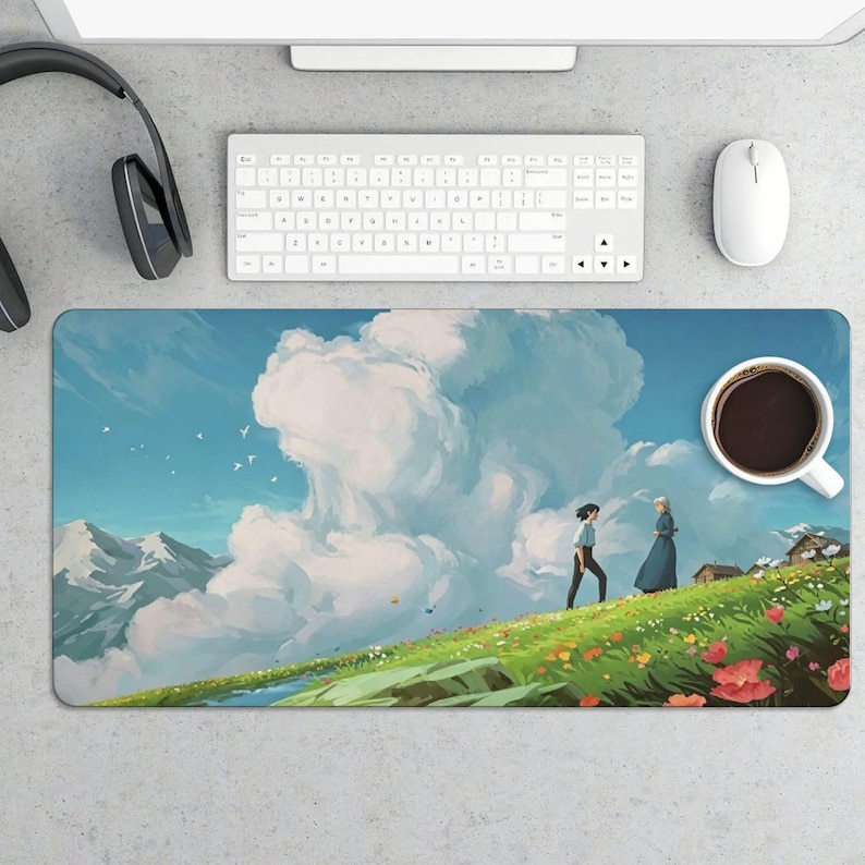 K&ouml;nnte beinhalten: Rechteckiges Mauspad mit einer lebendigen Illustration eines grasbewachsenen H&uuml;gels mit Blumen, blauem Himmel und zwei Figuren, die gehen. Eine Tasse Kaffee befindet sich rechts. Tastatur, Maus und Kopfh&ouml;rer sind ebenfalls sichtbar.