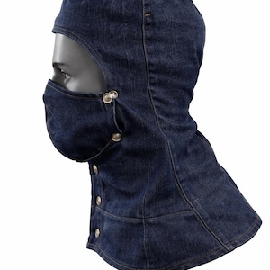 Pu&ograve; includere: Un passamontagna in denim blu scuro con una copertura per il viso e una chiusura con bottoni. Il passamontagna copre la testa e il collo, con un'apertura per gli occhi. La copertura per il viso &egrave; fissata con bottoni argentati.