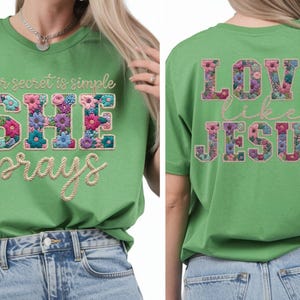 Peut inclure: T-shirt vert avec le texte floral "her secret is simple SHE prays" sur le devant. Le dos du t-shirt dit "LOVE like JESUS" en lettres florales. Le t-shirt est associé à un jean bleu.