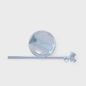 May include: A pale blue tumbler lid with a matching straw and decorative bow. The lid features a sliding closure and a small, embossed design. The straw is straight and the bow is detailed.