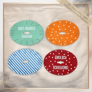 May include: Four oval-shaped craft discs with notched edges and a central cutout. One is mint green with the text "BEST FRIENDS FOREVER," one is orange with white dots, one has blue and white diagonal stripes, and one is red with white dots and the text "ENDLICH SCHULKIND."
