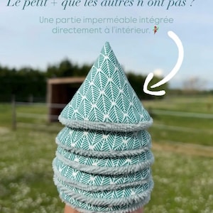 May include: A stack of reusable facial rounds with a green and white leaf pattern and a gray, fluffy border. The text in the image reads, "Le petit + que les autres n'ont pas ? Une partie imperméable intégrée directement à l'intérieur."