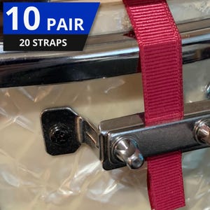 May include: Close-up of a drum component with a claret strap. The image shows a metal bracket and hardware, with the text "10 PAIR 20 STRAPS" in a blue and white box.