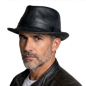 May include: A black leather fedora hat with a slightly curved brim. The hat has a structured crown and a band around the base. The hat is worn by a person wearing a black leather jacket.