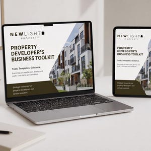 May include: A laptop and tablet displaying a business toolkit. The screens show the text "NEWLIGHT PROPERTY PROPERTY DEVELOPER'S BUSINESS TOOLKIT" with a building image. A small potted plant and notebook are also on the white surface.