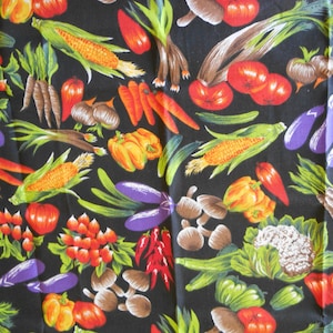 May include: A black fabric with a colorful vegetable print. The design includes corn, tomatoes, carrots, peppers, eggplants, mushrooms, and other vegetables. The vegetables are in shades of red, orange, yellow, green, and purple.