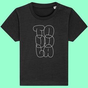 May include: Black short-sleeved t-shirt with white outlined text that reads "TO GO GA". The shirt has a crew neck and two snap closures on the shoulder. The shirt is for ages 12-18 months.