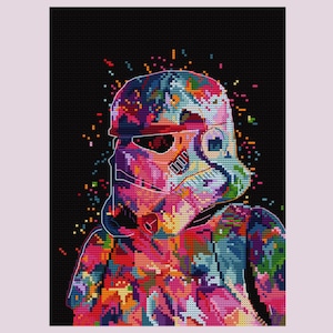 May include: A colorful cross-stitch pattern of a Stormtrooper helmet against a black background. The helmet is rendered in a vibrant array of colors, including pink, blue, orange, and green, with a pixelated effect. The artwork has a pop art style.