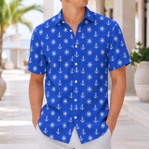 May include: A short-sleeved button-down shirt in a vibrant royal blue color featuring a repeating white pattern of nautical ship wheels and anchors. The garment has a classic collar, a front button placket, and a straight hemline design.