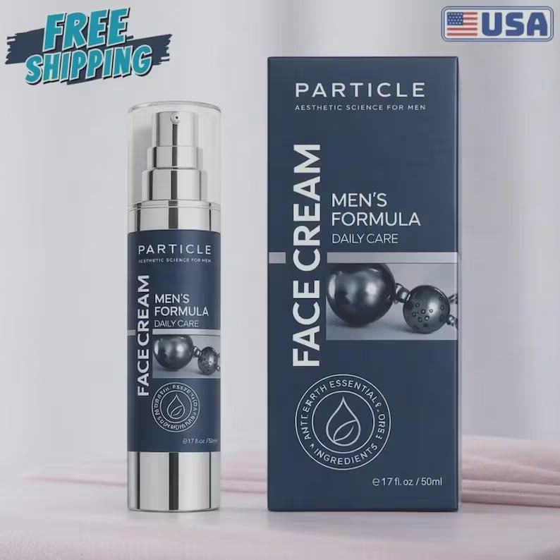 Op de afbeelding: Een donkerblauwe gezichtscr&egrave;mefles en -doos met de tekst "Particle Aesthetic Science for Men". De fles is zilverkleurig met een pompdosering. Op de doos staat "Men's Formula Daily Care" en "Face Cream". Het product bevat 50 ml.
