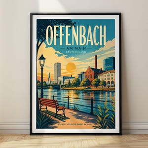 Può includere: Un poster di viaggio incorniciato di Offenbach am Main, Germania, che mostra una vista sul fiume con una panchina, un lampione ed edifici cittadini sotto un cielo al tramonto. Il testo recita OFFENBACH AM MAIN DEUTSCHLAND e KREATIV. VIELFÄLTIG. DIREKT AM MAIN.