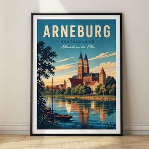 Op de afbeelding: Een ingelijste reisposter van de stad Arneburg, Deutschland, met de tekst 'ARNEBURG', 'DEUTSCHLAND' en 'Altmark an der Elbe'. De illustratie toont een rivier met boten, een kerk met twee torens en bomen onder een blauwe lucht.