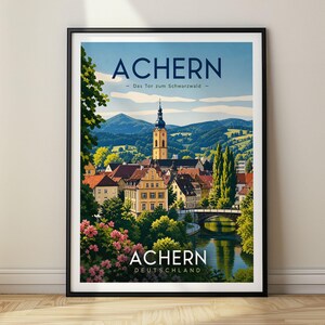 Puede incluir: Un póster de viaje enmarcado con una ilustración escénica de Achern, Alemania. La obra muestra un pueblo con una torre de iglesia, un río y montañas bajo un cielo azul. El texto dice ACHERN - Das Tor zum Schwarzwald - y ACHERN DEUTSCHLAND.