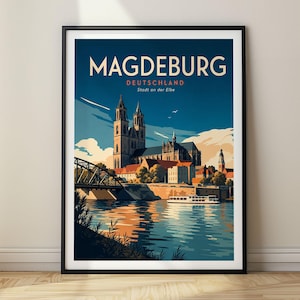 Może przedstawiać: Oprawiony plakat podróżniczy przedstawiający stylizowaną ilustrację katedry w Magdeburgu w Niemczech. Grafika ukazuje wieże katedry, most oraz łódź na rzece Łabie, wraz z napisem MAGDEBURG DEUTSCHLAND Stadt an der Elbe.