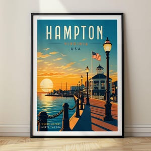 Pode incluir: Um cartaz de viagem emoldurado de Hampton, Virgínia, EUA, com um pôr do sol sobre um calçadão à beira-mar com corrimão de corrente, postes de luz, um coreto e uma bandeira americana. O texto diz HAMPTON VIRGINIA USA e WHERE HISTORY MEETS THE SEA.