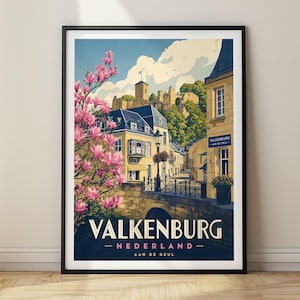 以下が含まれることがあります： オランダのファルケンブルフの風景を描いた額入りトラベルポスター。石橋、歴史的な建物、丘の上の城、ピンク色のモクレンの花が描かれています。テキストには「VALKENBURG NEDERLAND AAN DE GEUL」と記されています。