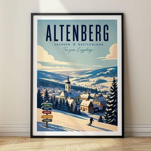 以下が含まれることがあります： アルテンベルク、ザクセン、ドイツの雪景色を描いた額装されたトラベルポスター。テキストには「ALTENBERG SACHSEN DEUTSCHLAND Tor zum Erzgebirge」と書かれています。教会、松の木、道標のある村の近くの斜面をスキーヤーが滑り降りています。
