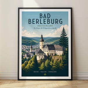Könnte beinhalten: Ein gerahmtes Reiseplakat mit einer Illustration von Bad Berleburg, Deutschland, mit Schloss, Wald und Stadt. Der Text lautet BAD BERLEBURG DEUTSCHLAND Im Herzen des Wittgensteiner Landes und NATUR KULTUR ERHOLUNG in dunkelblauer Schrift.