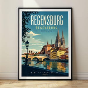 May include: A framed travel poster featuring a scenic view of Regensburg, Germany, with the Danube River, a stone bridge, and the cathedral. The text reads REGENSBURG, REGENSBURG, DEUTSCHLAND, and STADT AN DONAU UND ZEIT in a clean, sans-serif font.