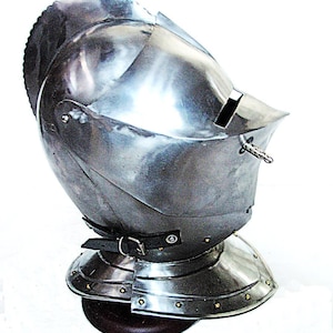 Op de afbeelding: Een gepolijste stalen helm met vizier en nekbescherming. De helm heeft een geklonken constructie en een leren riem. Het vizier heeft een smalle oogsleuf. De helm is waarschijnlijk voor historische re-enactment of tentoonstelling.