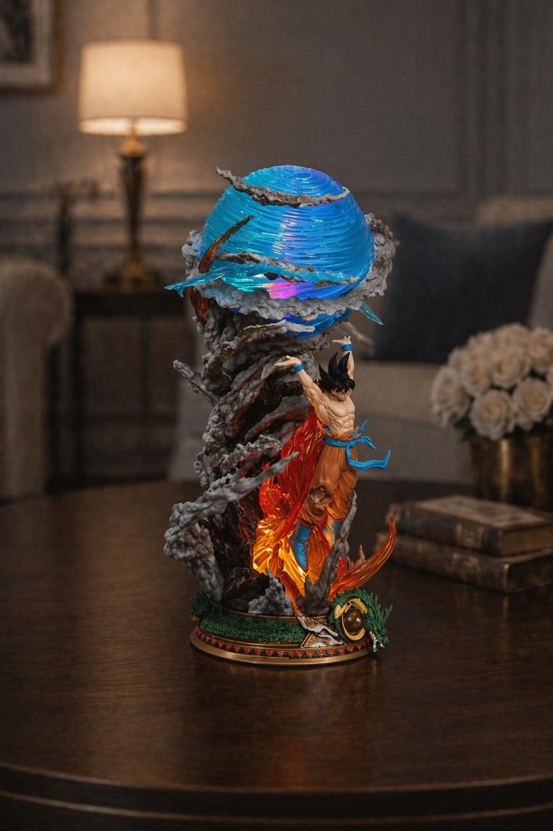 May include: A detailed figurine of a character with spiky black hair, wearing orange and blue attire, amidst a fiery, smoky display. A blue orb with light effects sits above the figure. The base is gold and green.