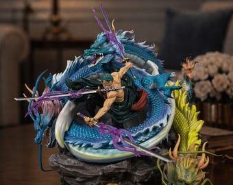 Pode incluir: Estatueta detalhada de um personagem empunhando espadas, rodeado por um dragão azul com detalhes roxos. A figura está em pose dinâmica, com um dragão verde e amarelo na base. A escultura está sobre uma superfície de madeira escura.
