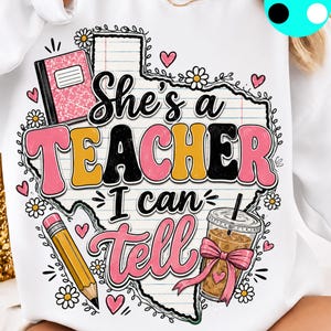 Puede incluir: Una sudadera blanca con un gráfico del estado de Texas relleno de papel rayado. El texto "She's a TEACHER I can tell" aparece en rosa, amarillo y negro. Las ilustraciones incluyen un cuaderno rosa, un lápiz amarillo y un café helado.