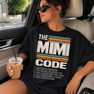 May include: Black t-shirt with the text "THE MIMI CODE" in a retro design. The shirt lists five rules, including "Bedtime is whenever" and "Hugs are mandatory." The shirt is worn by a person wearing sunglasses.