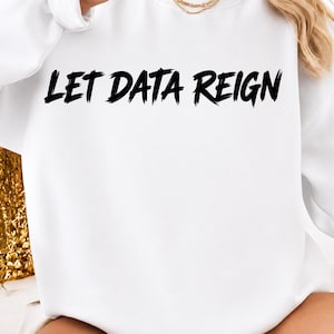 Pode incluir: Uma camisola branca de manga comprida com gola redonda, apresentando o texto LET DATA REIGN impresso numa fonte preta e arrojada com estilo de pincelada no peito. A peça tem um corte clássico com punhos e gola canelados.