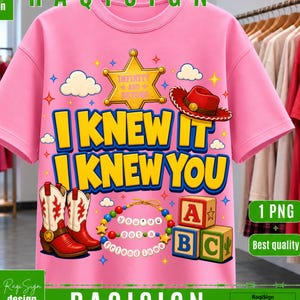 Op de afbeelding: Een roze t-shirt met een grafische print van een gele sheriffster, een rode cowboyhoed en een paar rood-witte cowboylaarzen. De tekst luidt I KNEW IT I KNEW YOU, INFINITY AND BEYOND en YOU'VE GOT A FRIEND IN ME op een kralenketting.