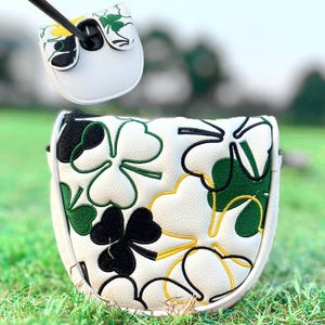Pu&ograve; includere: Copertura bianca per putter da golf con un design a trifoglio nero, verde e giallo. La copertura &egrave; realizzata in materiale strutturato e ha una chiusura magnetica. La mazza da golf &egrave; inserita nella copertura.