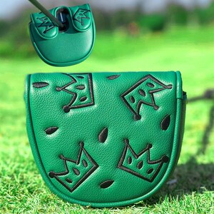 Pu&ograve; includere: Copertura per putter da golf verde con disegni di corone ricamate nere e forme a goccia. La copertura &egrave; realizzata in materiale strutturato e viene mostrata su un campo da golf verde. Una copertura pi&ugrave; piccola &egrave; mostrata sopra.