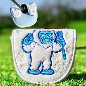 Pu&ograve; includere: Copertura per la testa della mazza da golf bianca e azzurra con un design yeti ricamato. Lo yeti &egrave; bianco con dettagli blu, che tiene in mano un bastone blu. La copertura ha una parte superiore azzurra e dettagli a fiocco di neve.