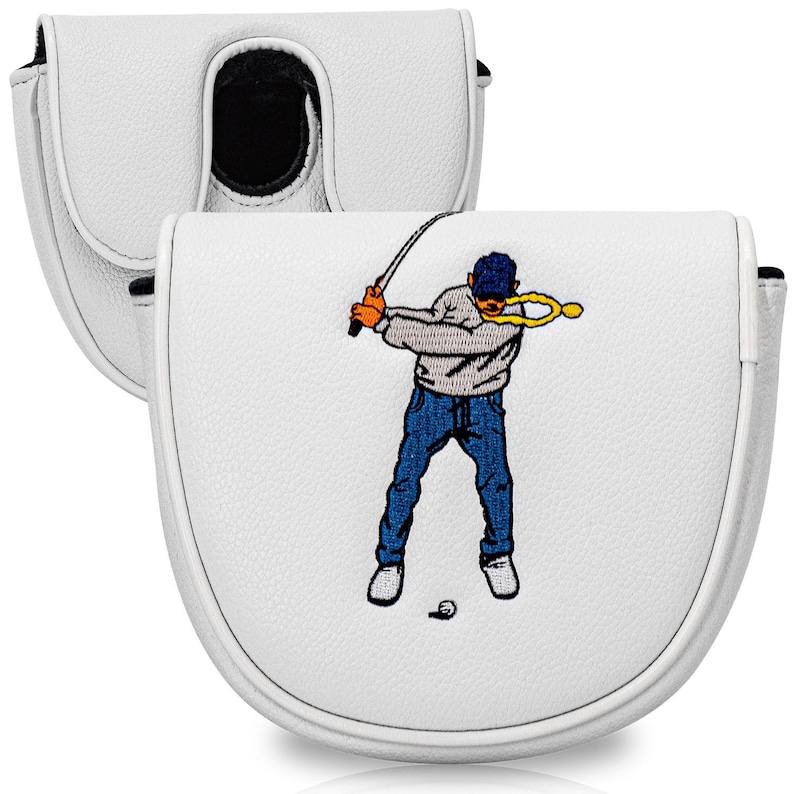 Puede incluir: Funda blanca para la cabeza del putter de golf con un golfista de dibujos animados bordado en la parte delantera. El golfista lleva una gorra azul, un su&eacute;ter gris y vaqueros azules. La bola de golf est&aacute; en el suelo. La funda tiene un interior negro.