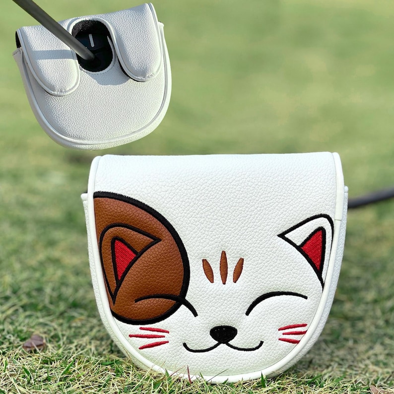 Pu&ograve; includere: Copertura bianca per la testa della mazza da golf con un design a forma di faccia di gatto sorridente. Il gatto ha un orecchio marrone, dettagli rossi e baffi neri. La copertura &egrave; in materiale strutturato.
