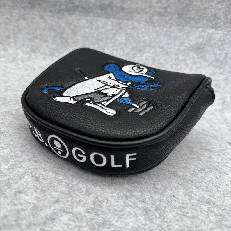 May include: Black golf club head cover with a cartoon mouse design in white, blue, and gray. The cover has the text "B.GOLF" in white. The cover is made of a textured material.