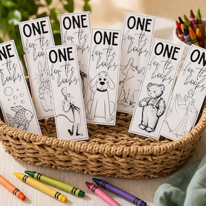May include: A collection of white bookmarks with black illustrations of a fish, rabbit, cat, dog, elephant, teddy bear, and princess. Each bookmark has the text "ONE for the books" in black. The bookmarks are in a woven basket with colorful crayons.
