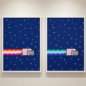 Op de afbeelding: Twee ingelijste prints met pixelafbeeldingen van een grijze kat met een roze lichaam, die met een regenboogstaart door de ruimte vliegt. De achtergrond is donkerblauw met witte sterren. De prints zitten in witte lijsten.