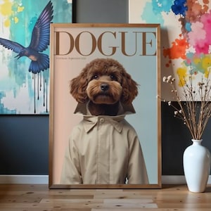 Pode incluir: Um cartaz emoldurado intitulado DOGUE apresentando um cão castanho de pelo encaracolado a usar um sobretudo bege. O texto diz DOGUE e First Issue September 2025. O cão tem uma expressão neutra e está centrado num fundo de gradiente suave.
