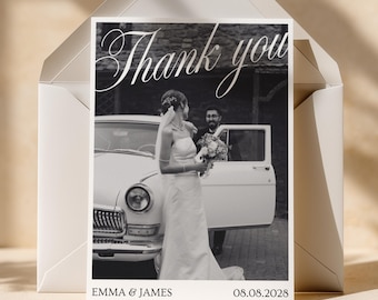 May include: A rectangular thank you card featuring a black and white photograph of a person in a wedding dress holding a bouquet next to a vintage car, with another person standing by the open door. The text reads Thank you, EMMA & JAMES, 08.08.2028.