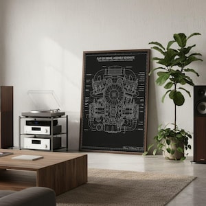 May include: A framed black and white print featuring a technical schematic of a flat-six engine with the text "FLAT-SIX ENGINE: ASSEMBLY SCHEMATIC" at the top, displayed in a room with audio equipment and potted plants.