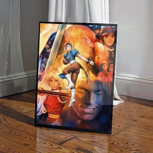 May include: A rectangular framed poster featuring a vibrant digital illustration of multiple characters from the Street Fighter video game series, including Chun-Li in her blue outfit and Maki in red, set against a warm, glowing orange background.