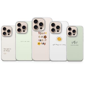 Puede incluir: Una colección de cinco fundas para teléfono con citas y diseños inspiradores. Las fundas presentan frases como "See good in all things", "Optimism" y "Today is a great day". Cada funda tiene un color y diseño diferente, incluyendo un sol sonriente y detalles florales.