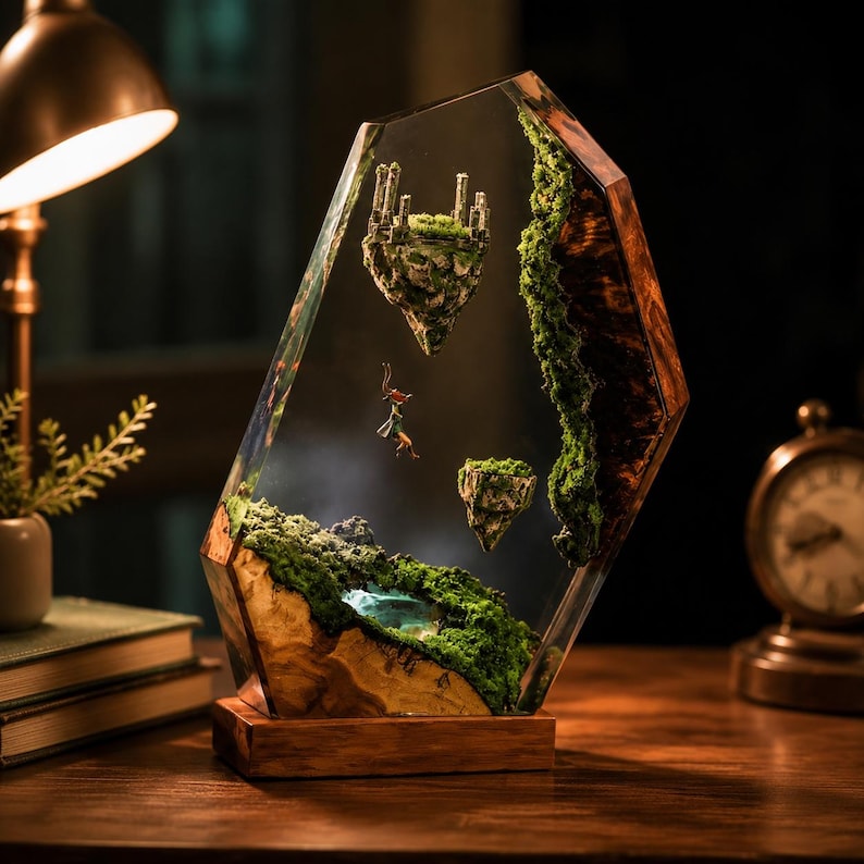 May include: A unique resin art piece featuring a miniature fantasy landscape. The clear resin encases floating islands with miniature castles and figures, surrounded by moss and a wooden base. The artwork is illuminated by a warm light.