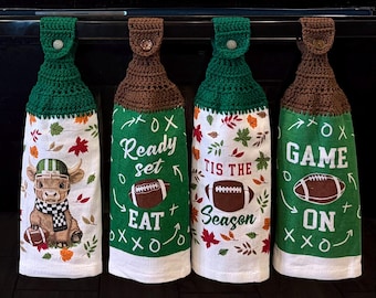 May include: Four hanging kitchen towels with crocheted tops and buttons. The towels feature football-themed designs, including a highland cow in a football helmet, autumn leaves, and text reading Ready set EAT, TIS THE SEASON, and GAME ON.