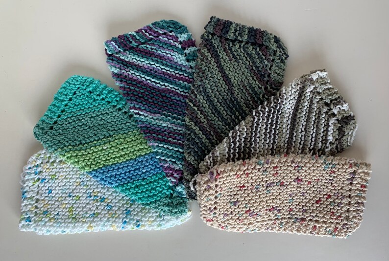Puede incluir: Cinco pa&ntilde;os de cocina de punto en varios colores y patrones, incluyendo verde, azul, morado, blanco y gris.